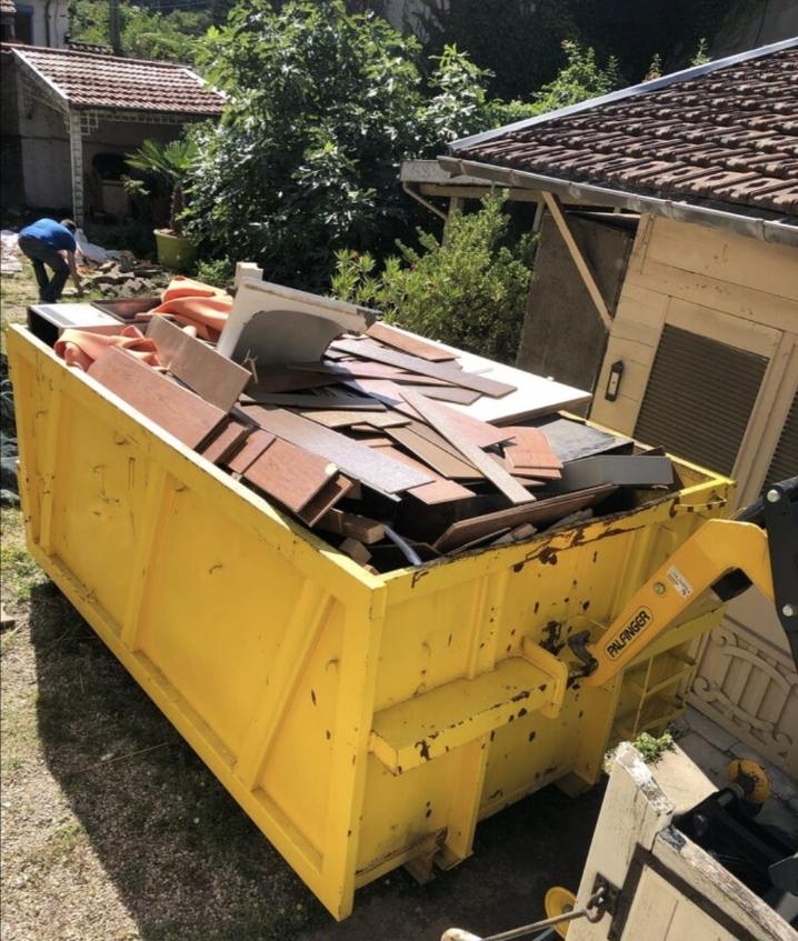 Benne jaune pleine de bois et matériaux de démolition